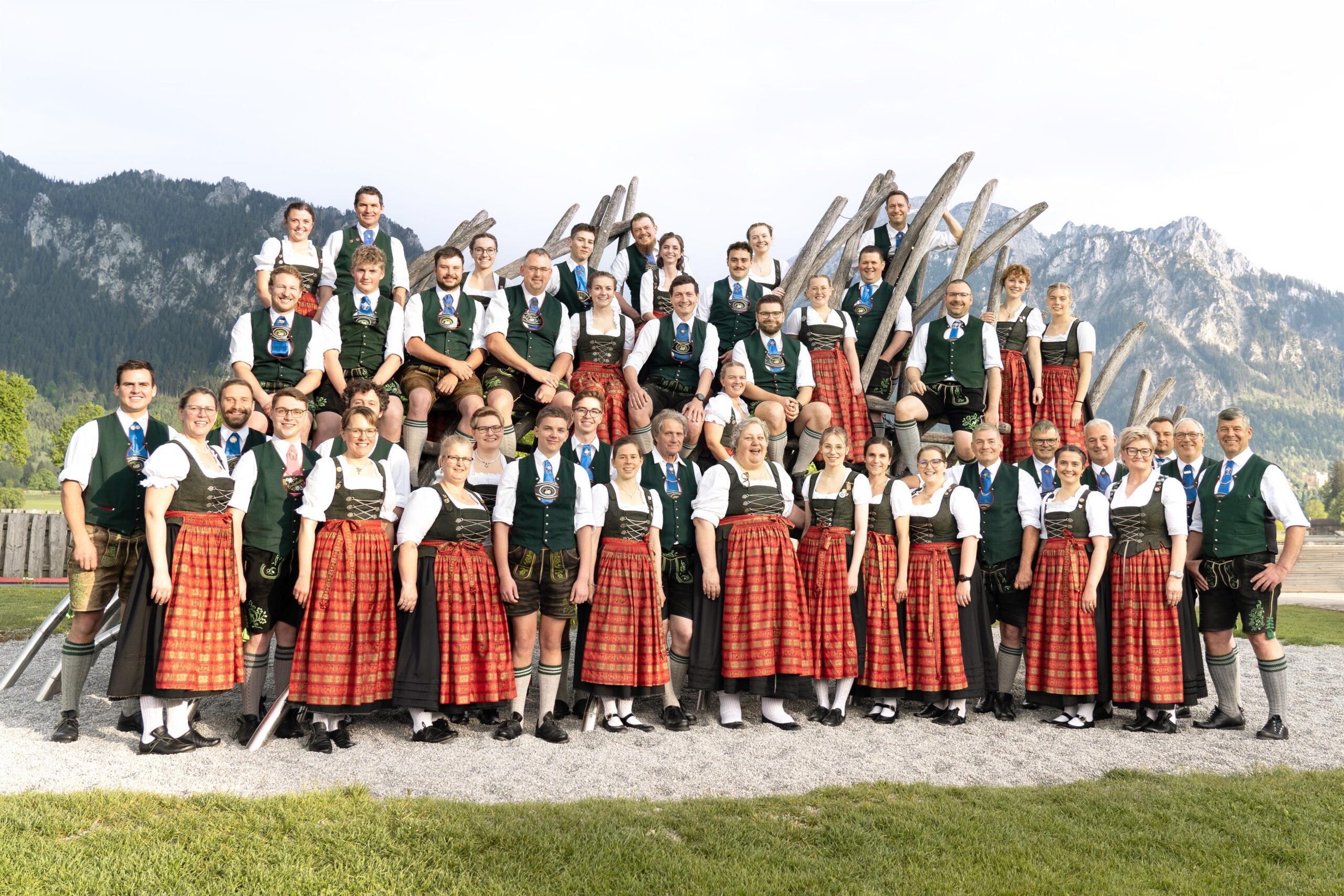 Eine Gruppe von Männern und Frauen in Dirndl und Tracht vor den Bergen